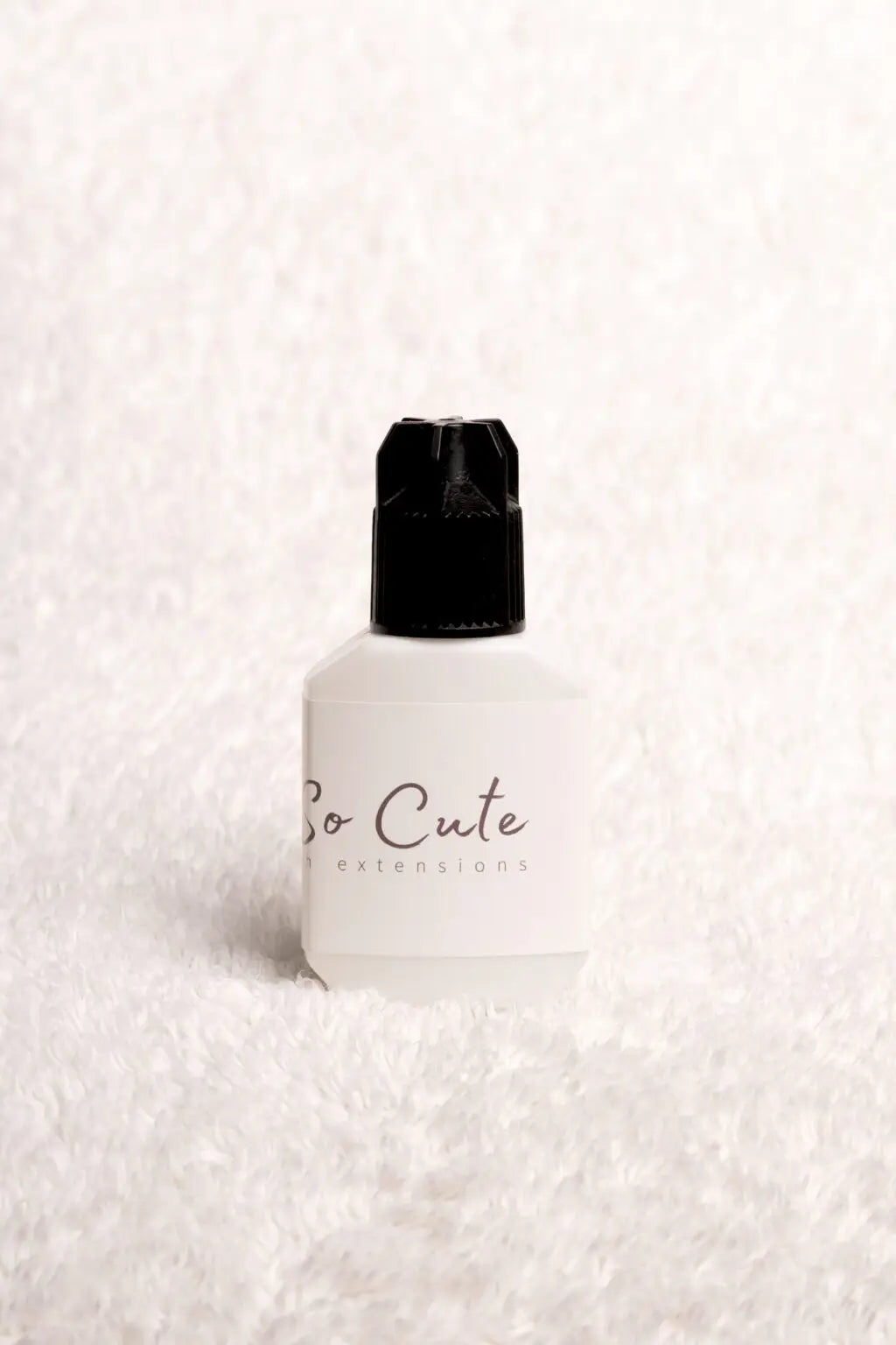 A white 10ml eyelash primer bottle with a black cap and so cute extensions for lash extension retention