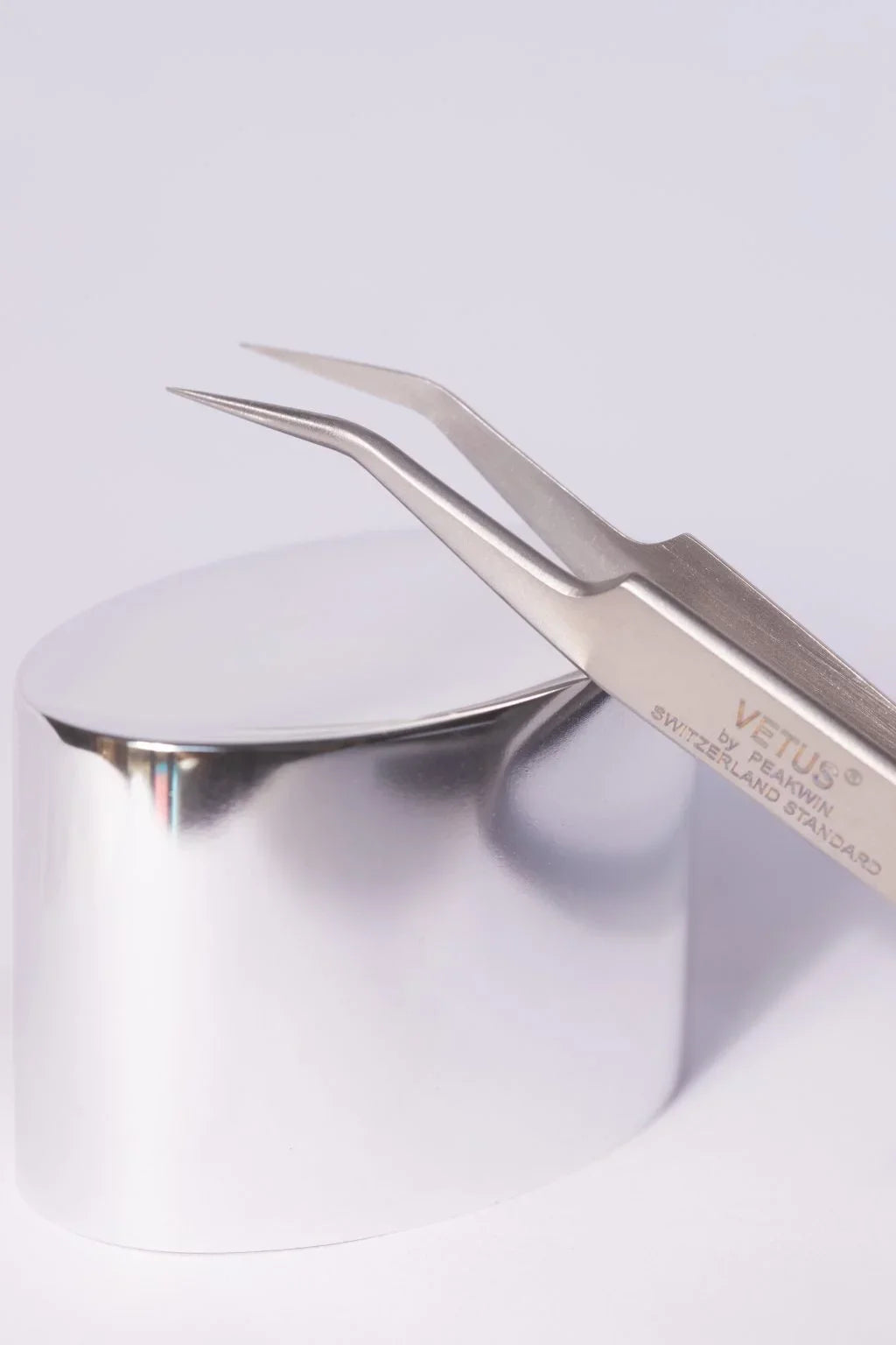 Silver Vetus precision tweezers with curved pointed tips and sleek metallic finish ideal for hypoallergenic adhesive glue use