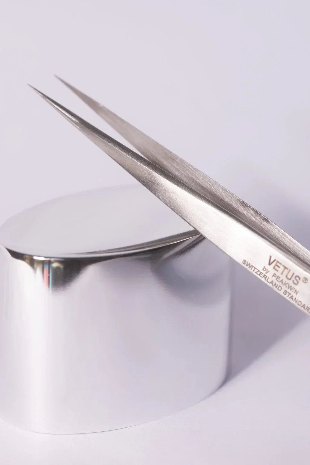 Silver precision tweezers with polished metallic finish and engraved branding perfect for hypoallergenic adhesive glue use